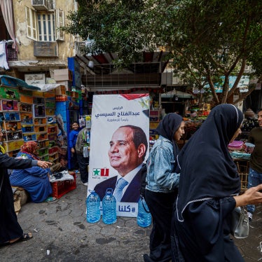 People walk past a campaign poster of Egypt's President Abdel Fattah al-Sisi in a market in Cairo ahead of the presidential election, December 7, 2023.