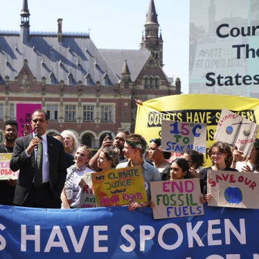 A man speaks during a demonstration with a banner that reads "Courts Have Spoken"
