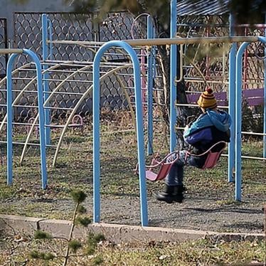 A boy sits on a swing in the courtyard of an orphanage for children with disabilities, Yerevan, Armenia.