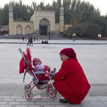 A woman tends to her child near the Id Kah Mosque in Kashgar in western China's Xinjiang region, November 4, 2017.